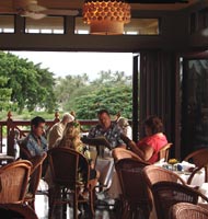 A family enjoys a pleasant dinner in the open air dining room at Tommy Bahama's on the Big Island